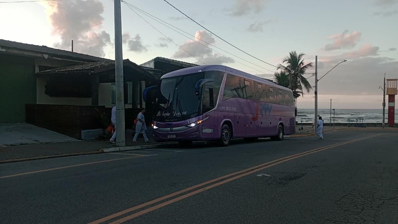 Ônibus da JRW embarcando passageiros na orla ao amanhecer