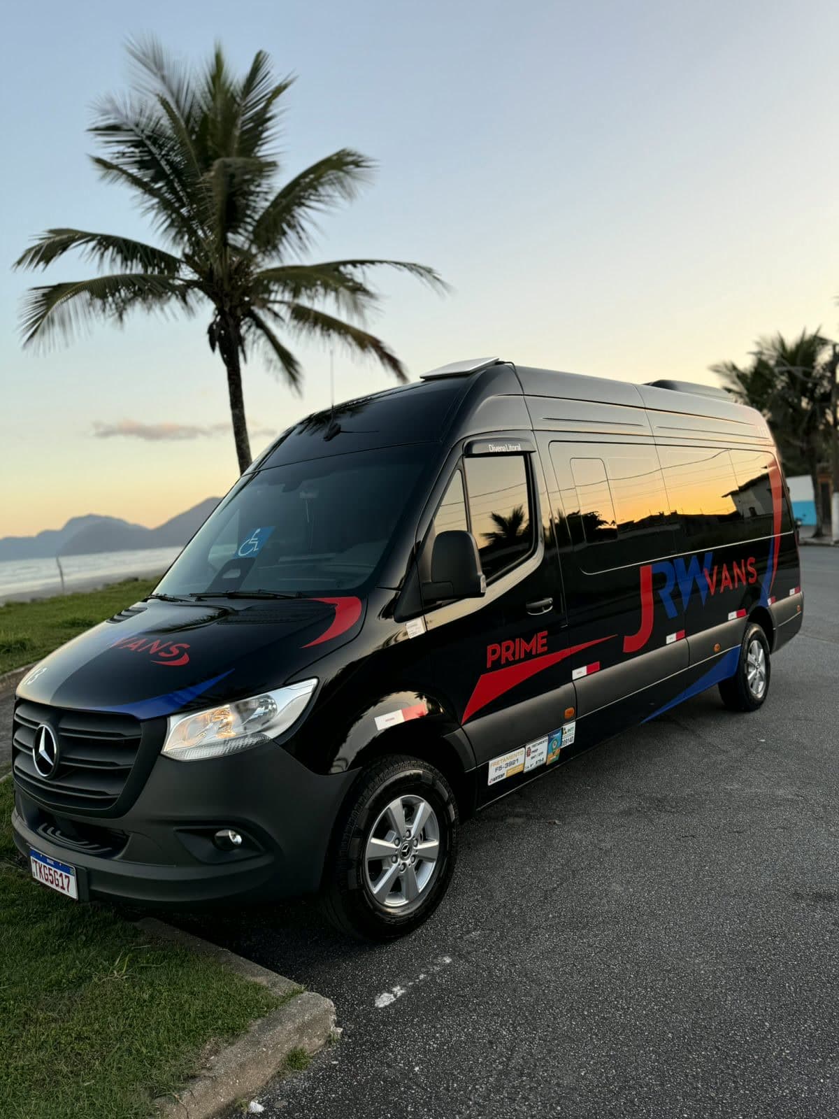 Van Mercedes-Benz Sprinter preta da JRW na orla ao entardecer