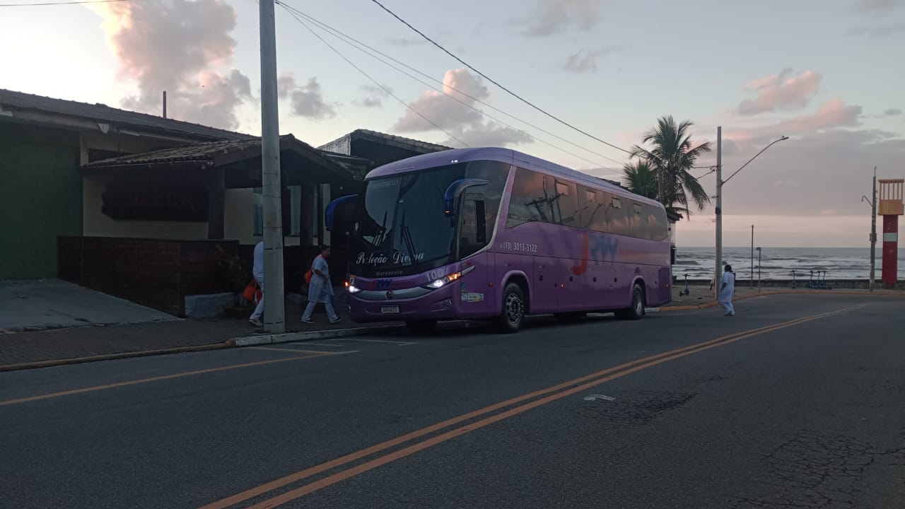 Ônibus JRW Transportes em frente à praia ao pôr do sol